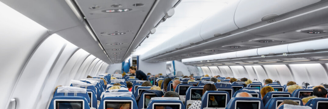 Cabin of modern aircraft with passengers on seats