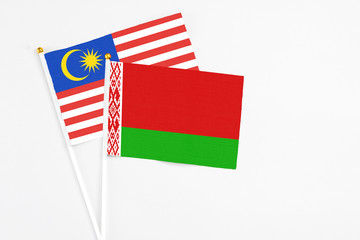 Belarus and Malaysia stick flags on white background. High quality fabric, miniature national flag. Peaceful global concept.White floor for copy space.