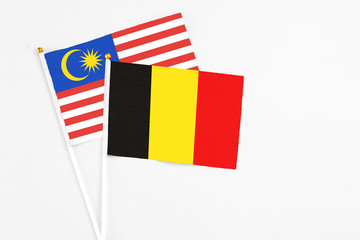 Belgium and Malaysia stick flags on white background. High quality fabric, miniature national flag. Peaceful global concept.White floor for copy space.