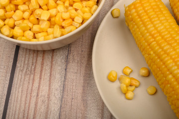 Two ears of boiled corn in a plate and a grain of corn on the table. Healthy diet. Fitness diet. For a sweet treat. Close up.