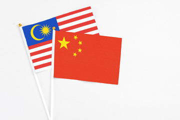 China and Malaysia stick flags on white background. High quality fabric, miniature national flag. Peaceful global concept.White floor for copy space.