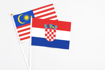 Croatia and Malaysia stick flags on white background. High quality fabric, miniature national flag. Peaceful global concept.White floor for copy space.