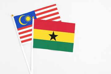 Ghana and Malaysia stick flags on white background. High quality fabric, miniature national flag. Peaceful global concept.White floor for copy space.