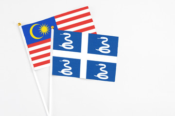 Martinique and Malaysia stick flags on white background. High quality fabric, miniature national flag. Peaceful global concept.White floor for copy space.