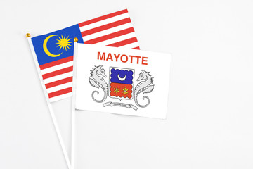 Mayotte and Malaysia stick flags on white background. High quality fabric, miniature national flag. Peaceful global concept.White floor for copy space.