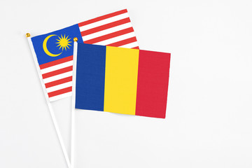 Romania and Malaysia stick flags on white background. High quality fabric, miniature national flag. Peaceful global concept.White floor for copy space.