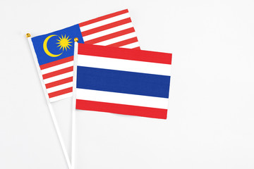 Thailand and Malaysia stick flags on white background. High quality fabric, miniature national flag. Peaceful global concept.White floor for copy space.