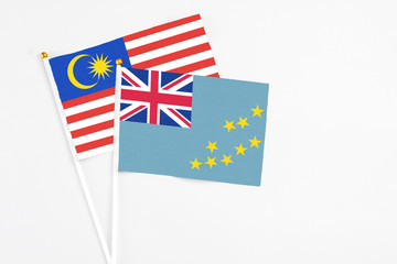 Tuvalu and Malaysia stick flags on white background. High quality fabric, miniature national flag....