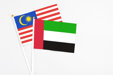 United Arab Emirates and Malaysia stick flags on white background. High quality fabric, miniature national flag. Peaceful global concept.White floor for copy space.