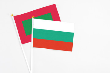 Bulgaria and Maldives stick flags on white background. High quality fabric, miniature national flag. Peaceful global concept.White floor for copy space.