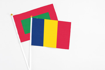 Chad and Maldives stick flags on white background. High quality fabric, miniature national flag. Peaceful global concept.White floor for copy space.