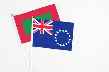 Fototapeta premium Cook Islands and Maldives stick flags on white background. High quality fabric, miniature national flag. Peaceful global concept.White floor for copy space.