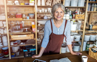 Portrait of senior female pottery artist in her art studio