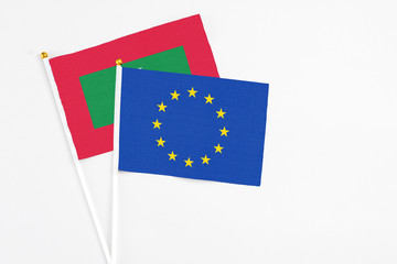 European Union and Maldives stick flags on white background. High quality fabric, miniature national flag. Peaceful global concept.White floor for copy space.