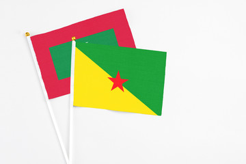 French Guiana and Maldives stick flags on white background. High quality fabric, miniature national flag. Peaceful global concept.White floor for copy space.