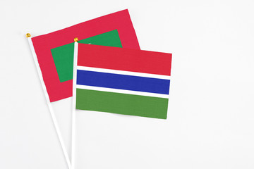 Obraz premium Gambia and Maldives stick flags on white background. High quality fabric, miniature national flag. Peaceful global concept.White floor for copy space.