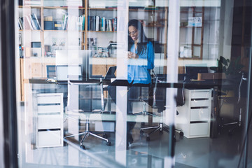Cheerful female using mobile phone during work pause
