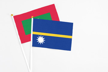 Nauru and Maldives stick flags on white background. High quality fabric, miniature national flag. Peaceful global concept.White floor for copy space.