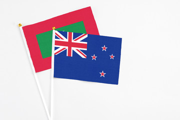 New Zealand and Maldives stick flags on white background. High quality fabric, miniature national flag. Peaceful global concept.White floor for copy space.