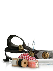 Pillow for needles, ancient thimbles, threads on wooden coils and scissors of the cutter