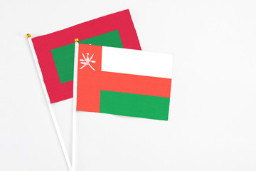 Oman and Maldives stick flags on white background. High quality fabric, miniature national flag. Peaceful global concept.White floor for copy space.