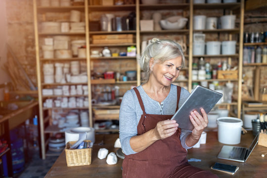 Senior craftswoman with tablet computer in art studio