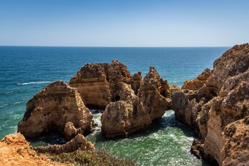 Fototapeta na wymiar Coastal cliffs and sea stacks near Ponta da Piedate, Lagos, Portugal.
