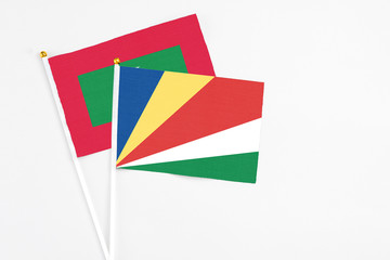 Seychelles and Maldives stick flags on white background. High quality fabric, miniature national flag. Peaceful global concept.White floor for copy space.