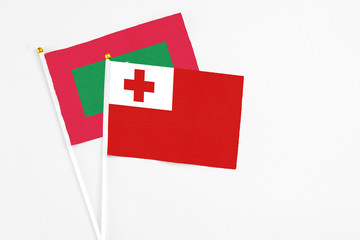 Obraz premium Tonga and Maldives stick flags on white background. High quality fabric, miniature national flag. Peaceful global concept.White floor for copy space.