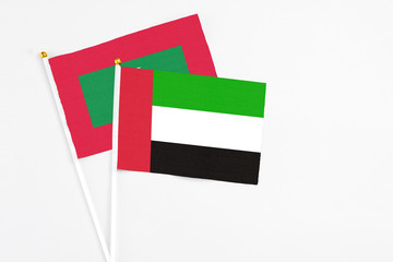 United Arab Emirates and Maldives stick flags on white background. High quality fabric, miniature national flag. Peaceful global concept.White floor for copy space.