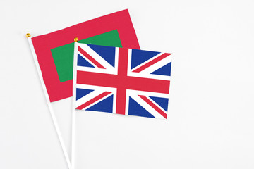 United Kingdom and Maldives stick flags on white background. High quality fabric, miniature national flag. Peaceful global concept.White floor for copy space.