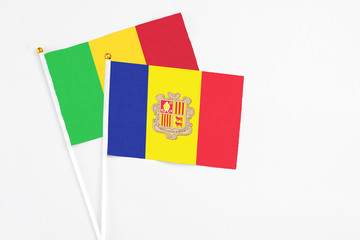 Andorra and Mali stick flags on white background. High quality fabric, miniature national flag. Peaceful global concept.White floor for copy space.