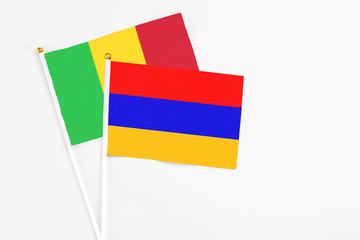 Armenia and Mali stick flags on white background. High quality fabric, miniature national flag. Peaceful global concept.White floor for copy space.