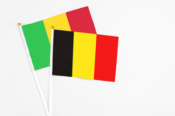 Belgium and Mali stick flags on white background. High quality fabric, miniature national flag. Peaceful global concept.White floor for copy space.