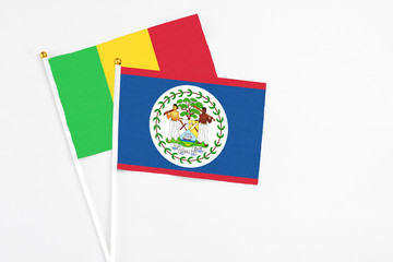 Belize and Mali stick flags on white background. High quality fabric, miniature national flag. Peaceful global concept.White floor for copy space.