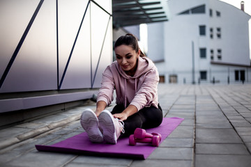 Fitness sport woman with fit body dressed black sportweart trainig workout outdoors against the street wall. Style sporty  girl do morning activity excercise