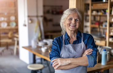 Portrait of senior female pottery artist in her art studio