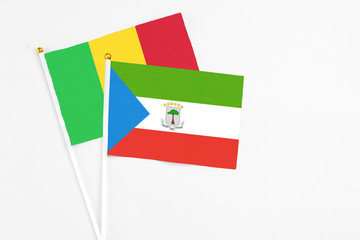 Equatorial Guinea and Mali stick flags on white background. High quality fabric, miniature national flag. Peaceful global concept.White floor for copy space.