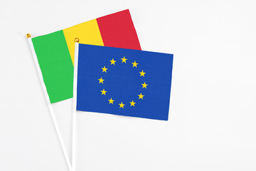 European Union and Mali stick flags on white background. High quality fabric, miniature national flag. Peaceful global concept.White floor for copy space.