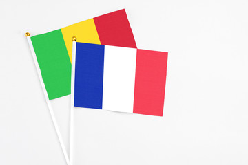 France and Mali stick flags on white background. High quality fabric, miniature national flag. Peaceful global concept.White floor for copy space.