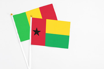 Guinea Bissau and Mali stick flags on white background. High quality fabric, miniature national flag. Peaceful global concept.White floor for copy space.