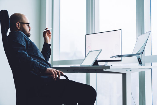 Pensive Man With Devices At Office Desk