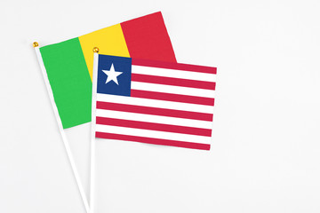 Liberia and Mali stick flags on white background. High quality fabric, miniature national flag. Peaceful global concept.White floor for copy space.