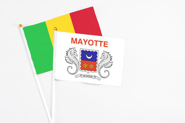 Mayotte and Mali stick flags on white background. High quality fabric, miniature national flag. Peaceful global concept.White floor for copy space.