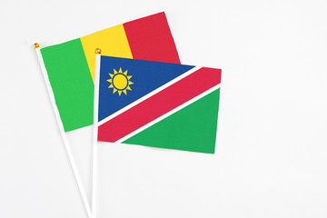 Namibia and Mali stick flags on white background. High quality fabric, miniature national flag. Peaceful global concept.White floor for copy space.