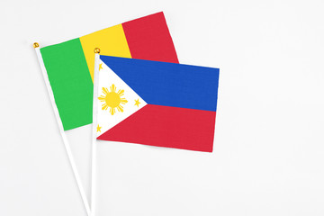 Philippines and Mali stick flags on white background. High quality fabric, miniature national flag. Peaceful global concept.White floor for copy space.