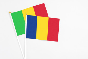 Romania and Mali stick flags on white background. High quality fabric, miniature national flag. Peaceful global concept.White floor for copy space.