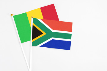 South Africa and Mali stick flags on white background. High quality fabric, miniature national flag. Peaceful global concept.White floor for copy space.