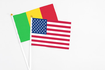 United States and Mali stick flags on white background. High quality fabric, miniature national flag. Peaceful global concept.White floor for copy space.