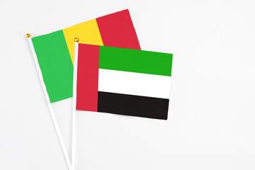 United Arab Emirates and Mali stick flags on white background. High quality fabric, miniature national flag. Peaceful global concept.White floor for copy space.